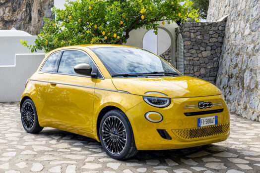 Κίτρινο FIAT 500 Hybrid σε πλακόστρωτο μεσογειακό τοπίο