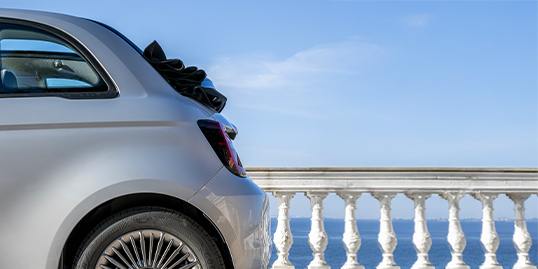 FIAT 500 Hybrid Cabrio με ανοιχτή υφασμάτινη οροφή δίπλα στη θάλασσα